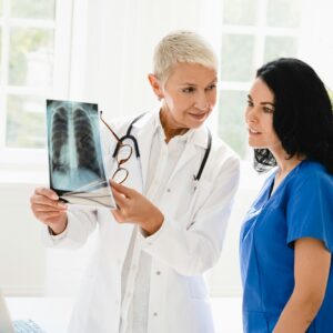 Doctor showing x-ray image of lungs to medical student intern nurse, explaining illness diagnosis